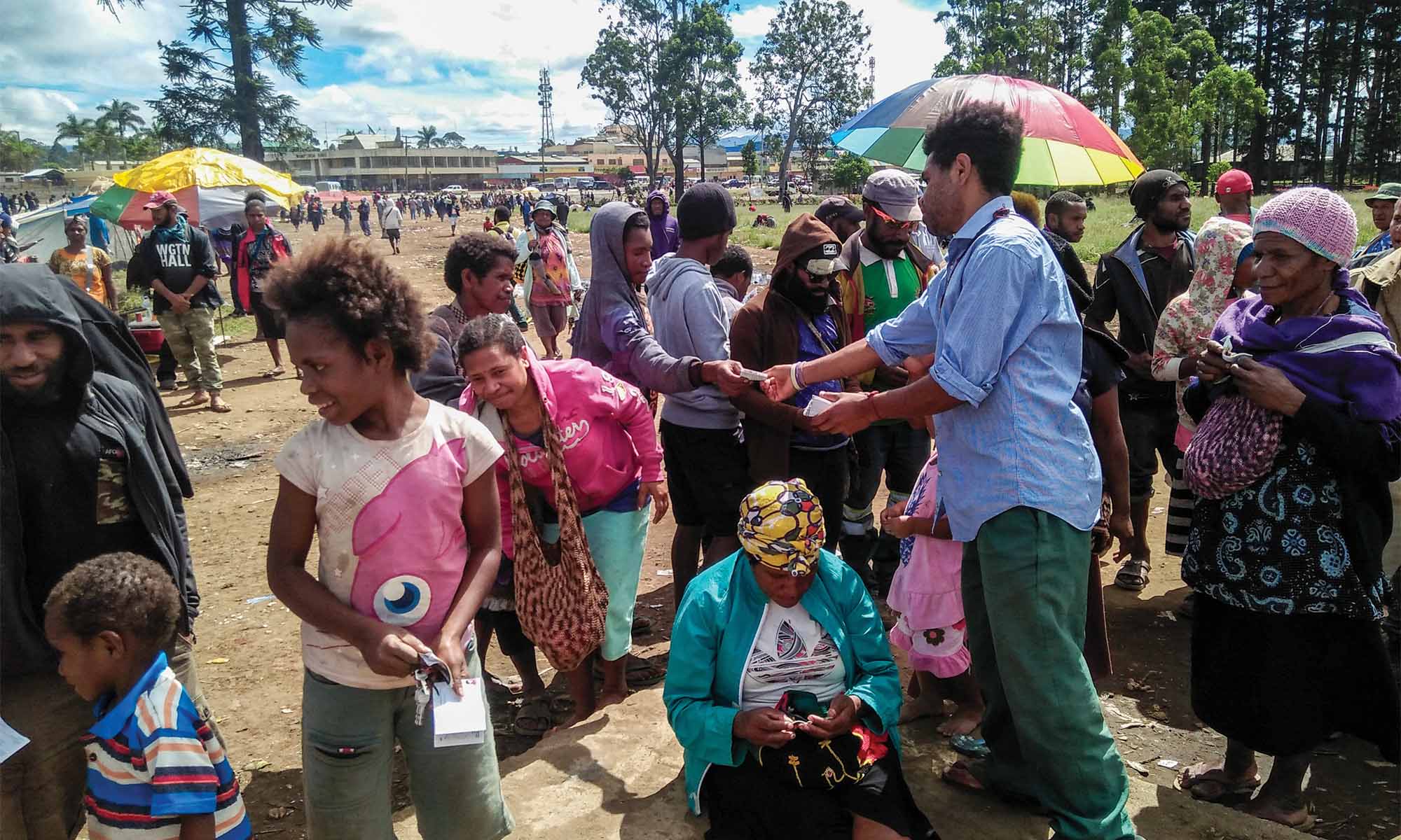 A local worker hands out EHC materials in a public area.