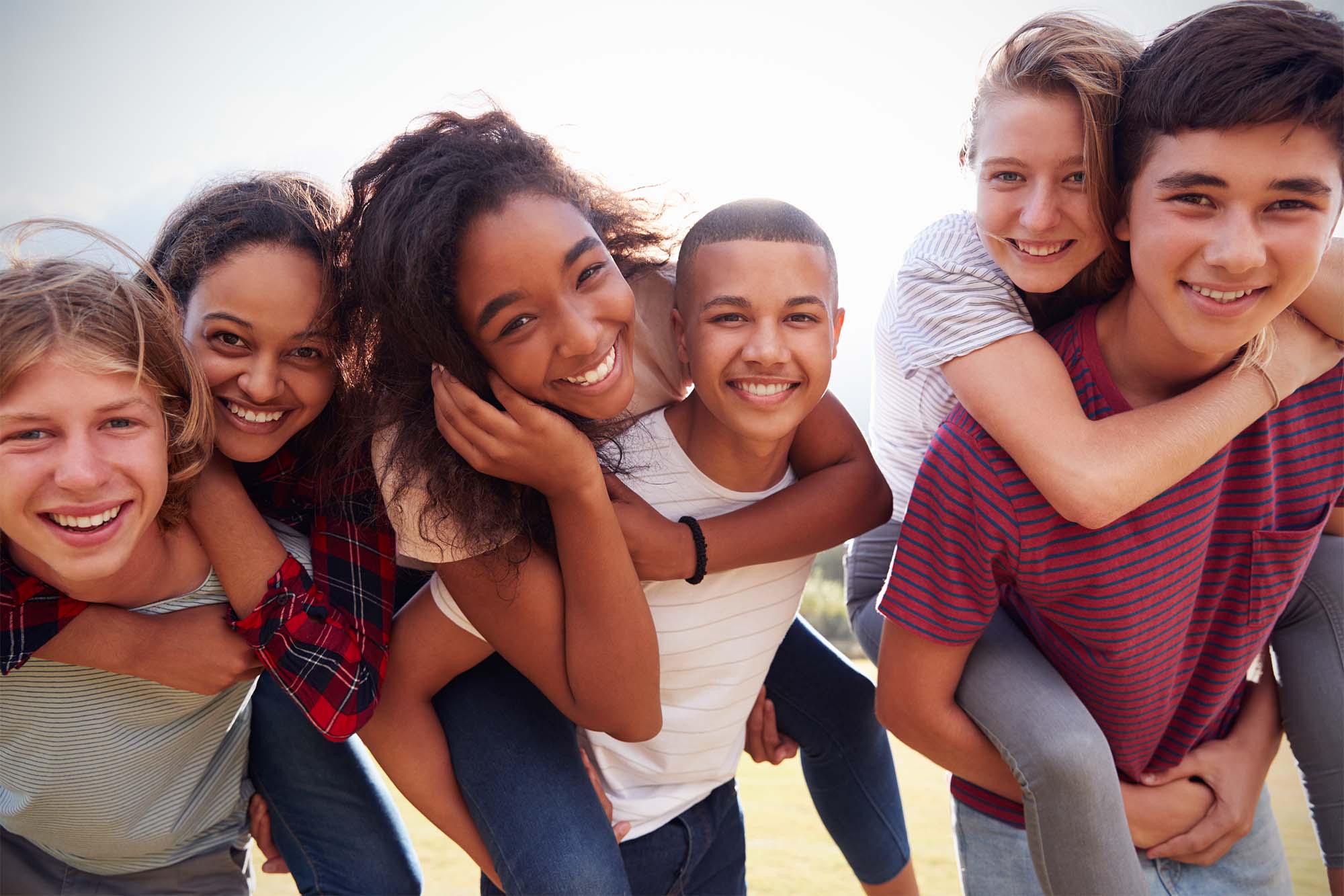 A group of diverse, smiling teenagers.