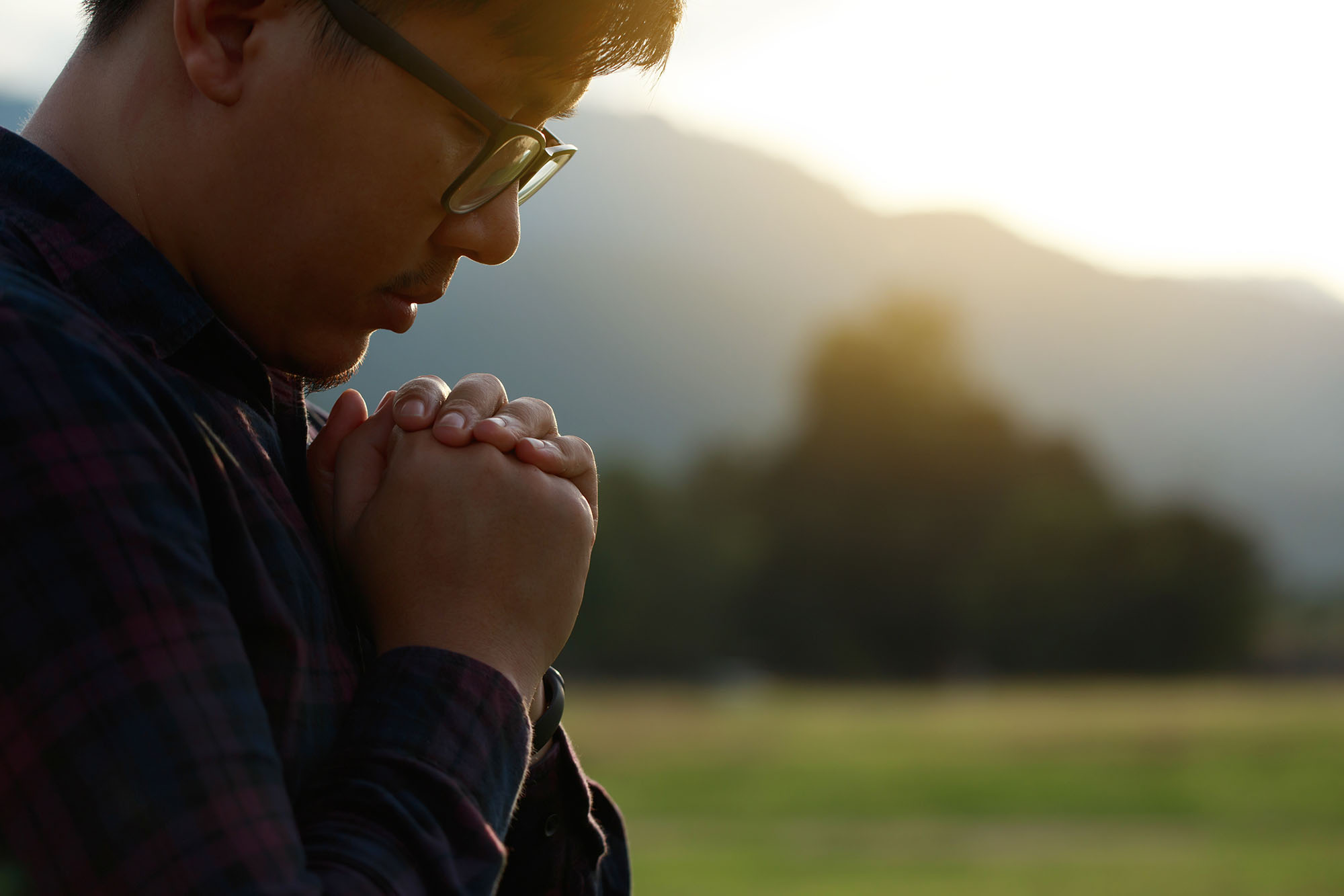 A man prays outside.
